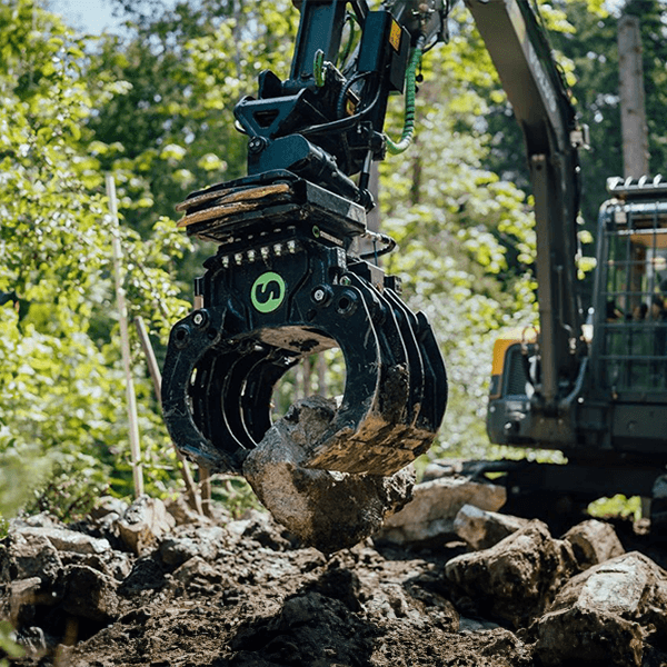 Tiltrator Steelwrist X07 z chwytakiem podczas przenoszenia kamienia koparką