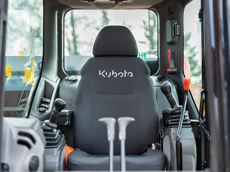 Kubota U145 – fotel i joysticki w kabinie operatora